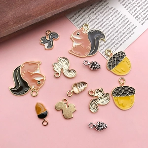 Detail of squirrel and acorn enamel charms with textured gold plated alloy back