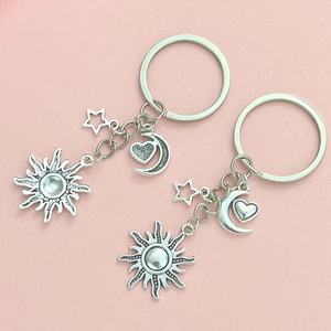 Detail of silver sun, moon and star charms on a creative DIY metal keychain set