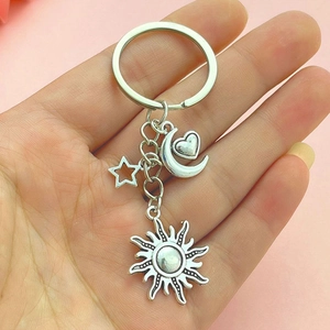 DIY silver alloy keychain featuring sun moon star and heart charms on a pink background