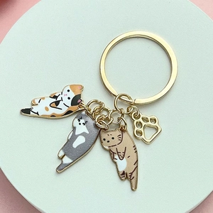 Detail of cute cat pendants and golden paw charm on a blue circular display stand