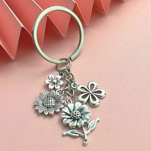 Detailed macro of silver sunflower and daisy charms on a premium metal keychain