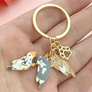 Cute cat theme keychain with enamel charms and golden paw pendant shown in hand