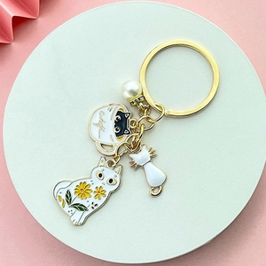 Portachiavi con gatto bianco carino, girasole e ciondolo a perla su sfondo rosa