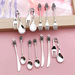 Detailed macro shot of vintage silver alloy miniature cutlery charms for DIY jewelry crafting