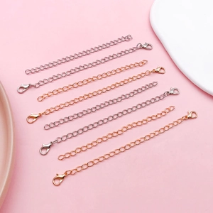 Close-up of polished silver and rose gold necklace extender chains with lobster clasps