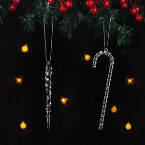 Macro detail of transparent icicle and candy cane ornaments hanging on Christmas tree