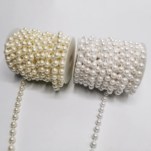 Vista macro de hilos de perlas blancas y beige en carretes para decoración de bodas