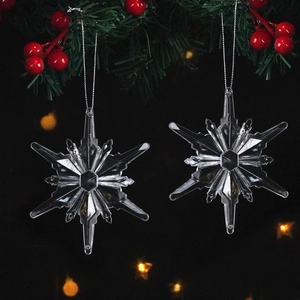 Close-up of sparkling crystal snowflake ornaments hanging with silver strings on a tree