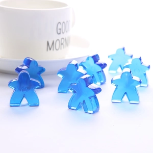 Satz transparenter blauer Kristall-Spielfiguren auf weißem Grund mit Tasse