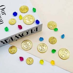 Close-up of gold pirate coins and colorful resin gems for board game accessories