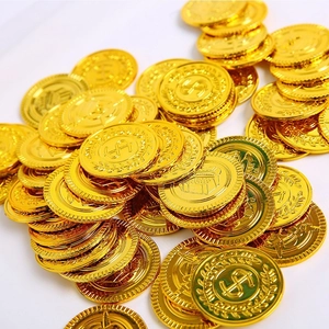 Macro view of gold plastic toy coins with embossed dollar signs and chest designs