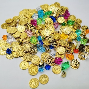 Close-up of golden pirate coins with skull motifs and colorful acrylic crystal gems