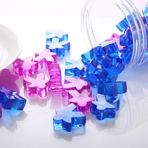 Macro shot of colorful transparent flower-shaped acrylic resin game pieces pouring out