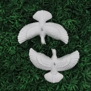 White dove Christmas ornaments set with wing details on green decorative background
