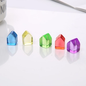 Close-up of five colorful transparent resin house pieces for tabletop board games