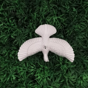 Macro detail of white peace dove hanging ornament with realistic feather texture