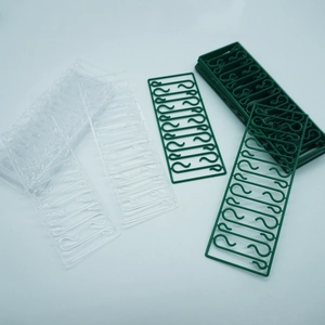 Detail view of S-shaped plastic Christmas ornament hooks in clear and green finishes