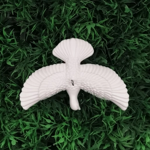 White dove hanging decoration with detailed feather texture on green grass background