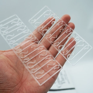 Detailed view of clear plastic S-shaped display hooks for hanging clothing tags and ornaments