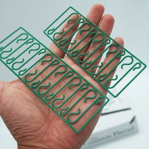 Close-up of small green S-shaped plastic hooks for Christmas tree decorations