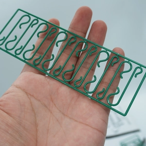 Close-up of green plastic S-hooks in a molded frame for hanging Christmas ornaments