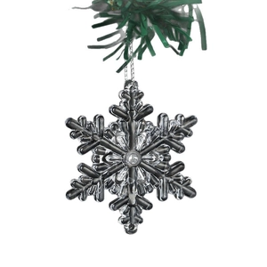 Clear crystal plastic snowflake ornament with silver hanging string and green pine needles