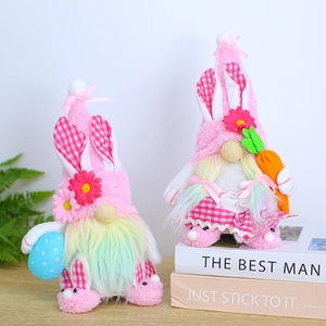 Pink Easter gnome plush with rainbow beard holding egg and carrot on wooden base