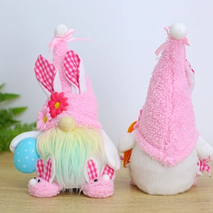 Pink plush Easter gnomes with bunny ears and LED lights on a light wood surface