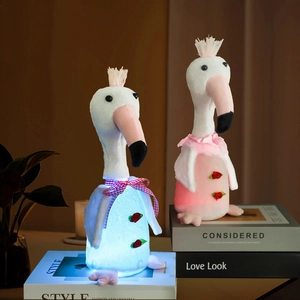 Macro shot of glowing flamingo plush toys with LED lights and bow tie on books