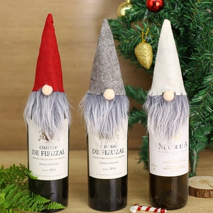 Three Christmas gnome wine bottle covers in red, grey, and white with long fiber beards