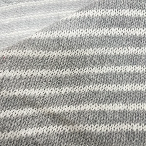 Close-up of grey and white striped knitted fabric with soft texture and neat stitching