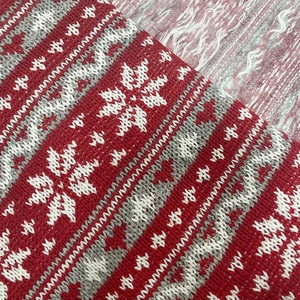 Detail of red and white Nordic snowflake knitted pattern on jacquard fabric