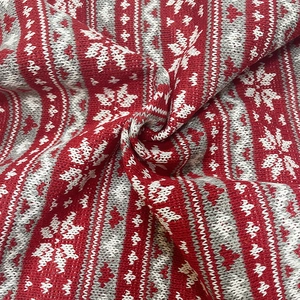 Red and white Christmas knit fabric with Fair Isle snowflake patterns and thick yarn texture