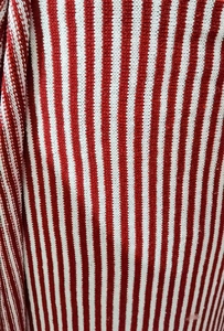 Close-up of knit fabric with classic Christmas red and white vertical stripe pattern
