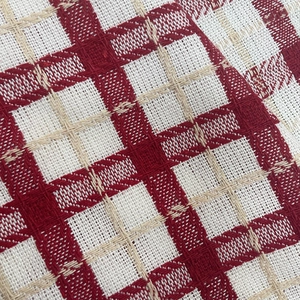 Close-up of red and white checkered knit fabric showing thick yarn weave and soft texture