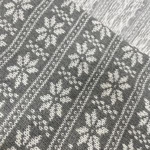 Detail of grey and white knitted snowflake jacquard fabric for Christmas pillows