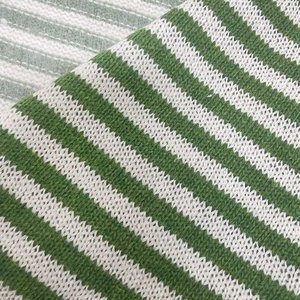 Macro view of green and white striped knit fabric with coarse needle texture