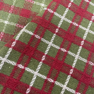 Close-up of red and green plaid knitted fabric with festive Christmas patterns