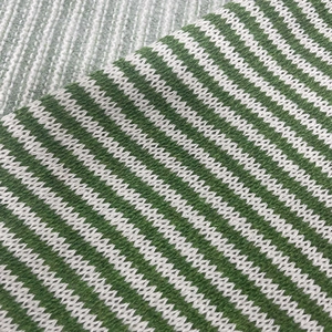 Macro detail of green and white striped knit fabric showing intricate weaving texture