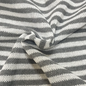 Close-up of gray and white striped knitted fabric texture with soft fold details