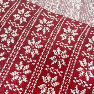 Close-up of Christmas knitted fabric featuring classic red and white snowflake patterns