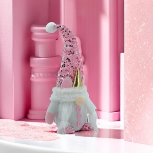 Pink unicorn gnome plush toy with sequins and gold horn on a modern geometric background