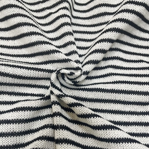 Close-up of black and white striped knit fabric with soft texture and spiral folds