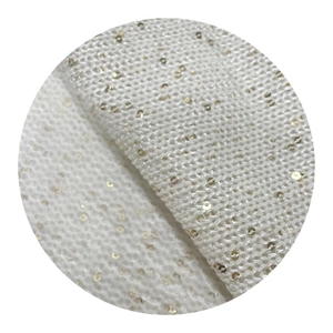 White knit fabric featuring dense gold sequins and soft metallic jacquard texture