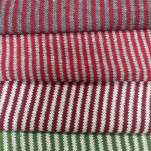 Striped knit fabric with herringbone texture in red, green, gray, and white stripes
