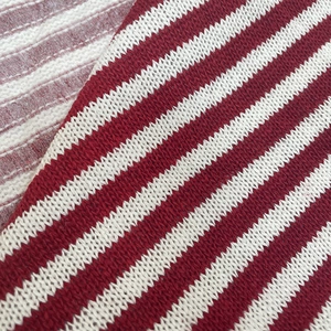 Macro shot of red and white striped knit fabric with soft texture for winter apparel
