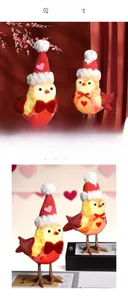 Detail of couple Christmas bird figurines with red knitted hats and sequin wings decor