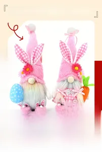 Detail of pink Easter gnome plushies with rabbit ears holding eggs and carrots