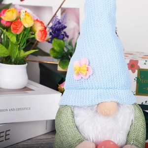 Close-up of Easter gnome plush with bunny ears holding a pink polka dot egg decor