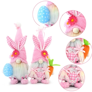 Pink Easter gnome plush with bunny ears holding egg and carrot on white background